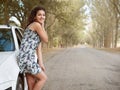 Girl stand on country road near car, big high trees, summer season Royalty Free Stock Photo