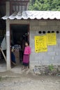 A girl stand beside a door in a Thailand village