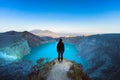 Girl stand on rock under volcano Kawah Ijen acid lake