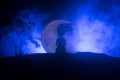 Girl standing alone behind big full moon. Dark toned foggy background. Loneliness bad mood concept Royalty Free Stock Photo