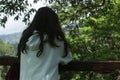 A girl standing alone in the wood from the back, looking at the forest view. Contemplation and self healing concept. Royalty Free Stock Photo