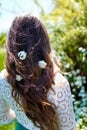 Girl standing back to camera with white spirea flowers in dark long wavy hair. Spring blossoming and tenderness Royalty Free Stock Photo