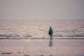 Girl standing on the beach and looking at the sea in a peaceful moment Royalty Free Stock Photo