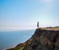 The girl is standing on a cliff near the sea Royalty Free Stock Photo