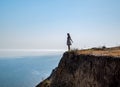 The girl is standing on a cliff near the sea Royalty Free Stock Photo