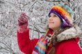 Girl standing in colorful warm clothes on snowy forest