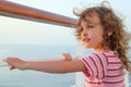 Girl standing on cruise liner deck, hands on rail