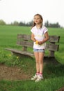 Girl standing in front of bench