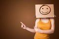 girl standing and gesturing with a cardboard box on her head with smiley face Royalty Free Stock Photo