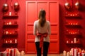 Girl standing with her back against a red background