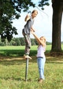 Girl standing on iron pillar with thumb up