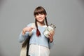 Girl standing isolated grey background with jar full of money Royalty Free Stock Photo