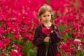girl in a cherry dress and pigtails collects bright pink flowers
