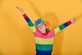 A girl is standing in a multi-colored sweater, waving her arms around the sides in a wig Royalty Free Stock Photo