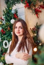 Girl standing near beautiful decorated Christmas tree and enjoying magic time of the year Royalty Free Stock Photo