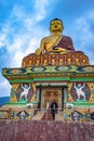 Girl standing near huge buddha golden statue with bright moody sky at evening Royalty Free Stock Photo