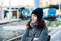 Girl standing near the railway station trying to hold back her tears - side view