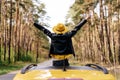 Girl Standing out of Yellow Car Sunroof Back View