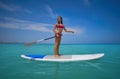 Girl standing on paddle surf board SUP