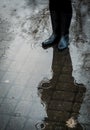 Girl standing in puddle in black rubber boots during the rain Royalty Free Stock Photo