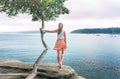 Girl looking out to see holding on to lone tree wind in her hair Royalty Free Stock Photo