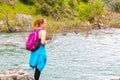 Girl Standing on Rocks Near Fast River