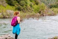 Girl Standing on Rocks Near Fast River