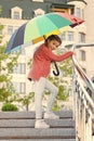 Girl standing on stairs and holding umbrella. Autumn rain. Waiting for bad weather under umbrella. Stylish girl in Royalty Free Stock Photo