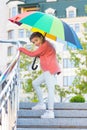 Girl standing on stairs and holding umbrella. Autumn rain. Waiting for bad weather under umbrella. Stylish girl in Royalty Free Stock Photo