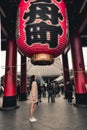 Girl standing under a great lantern Kaminarimon in Asakusa Tokyo Japan