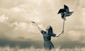 Girl is standing on a wheat field with pinwheel Royalty Free Stock Photo