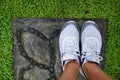 Girl standing in white shoes on green grass. Royalty Free Stock Photo