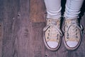 Girl standing with worn out sneakers