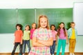 Girl stands with arms crossed near blackboard Royalty Free Stock Photo