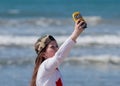 Girl stands on the beach and makes selfie using your mobile phone