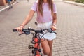 A girl stands with a bicycle in summer in the city. Close-up steering wheel and brakes, with a security secret lock on Royalty Free Stock Photo