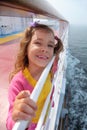 Girl stands on board of ship, clings to railing