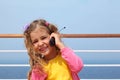 Girl stands on board ship, says by portable radio Royalty Free Stock Photo