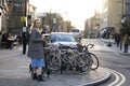 Girl stands at a crossroads amid parked bicycles, about to cross the road