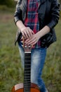 A girl stands with a guitar without playing, strings at rest, la