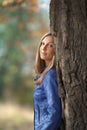 Girl stands of a large oak tree Royalty Free Stock Photo