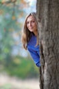 Girl stands of a large oak tree Royalty Free Stock Photo