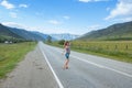 A girl stands on a mountain road. Royalty Free Stock Photo