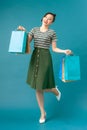 Girl stands on one leg and holds purchases in her hands after shopping Royalty Free Stock Photo