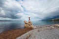 The girl stands on a pile of stones and looks at the sea