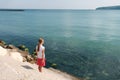 Girl stands on the shore and looks at the sea Royalty Free Stock Photo