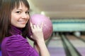 Girl stands sideways and smiles with ball in hands