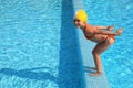 Girl stands on skirting in pool