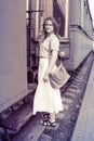 A girl stands on the steps of the cars train. Historical monochrome photo of a woman on the footboard of the car. The vintage