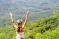 Girl stands on a top of the mountain with her hands up looking at beautiful mountain landscape .A girl stands with her hands up Royalty Free Stock Photo